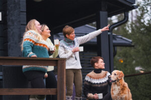 Ystävät ja koira ihailemassa Himoksen maisemia mökin terassilla.