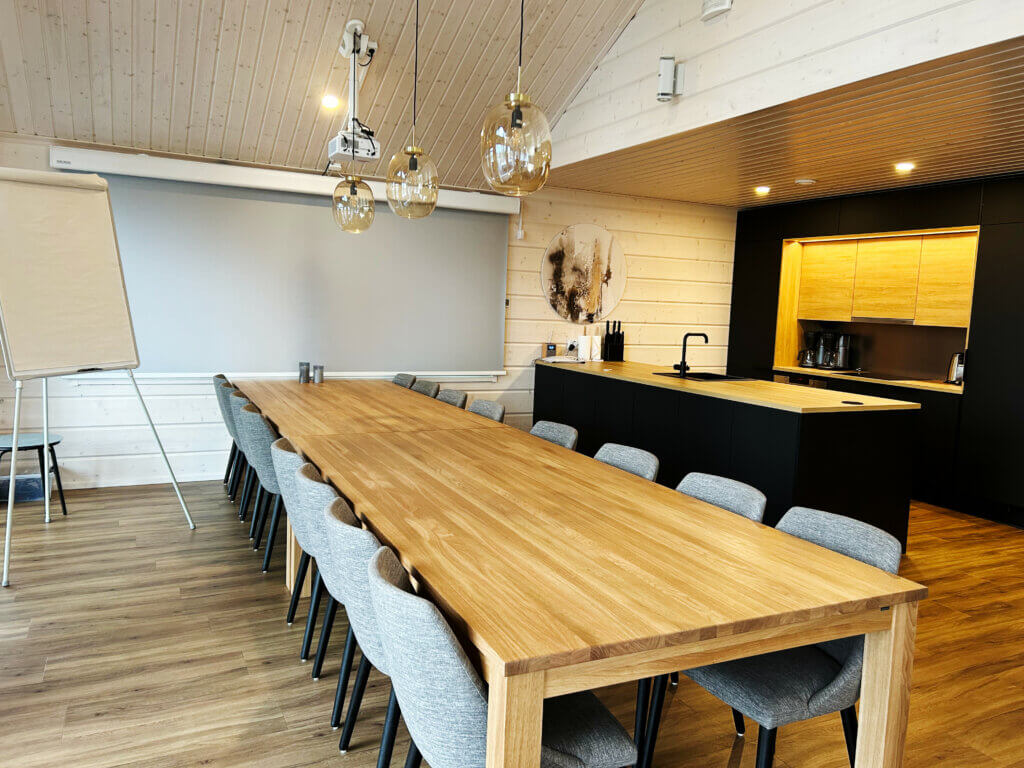 HimosLomien huvila Hillside, jossa on iso pöytä ja tarvittavat varusteet kokousta varten.