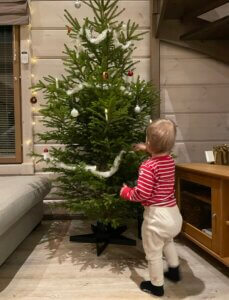 Lapsi kortistelemassa joulukuusta Himoksen mökillä.