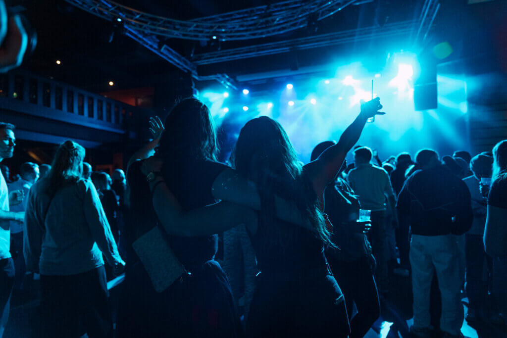 Ilta Himos Areenalla: sinisävyisessä kuvassa juhlijoita tanssimassa keikalla.