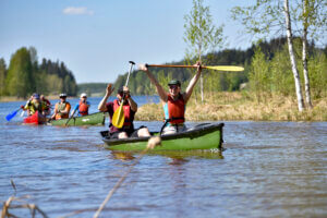 Melojia, etummaisessa kajakissa toinen meloja nostanut melan käsiensä varaan ylös.
