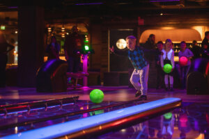 Nuori lapsi hohtokeilaa, taustalla useita lapsia seuraamassa suoritusta.