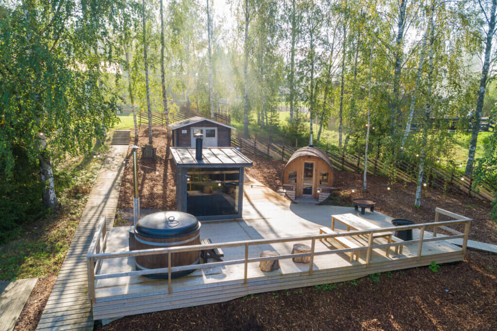 Ilmakuva kesällä, jossa näkyy Himoksen saunapihaa. Palju ja kaksi saunaa puisella isolla terassilla.