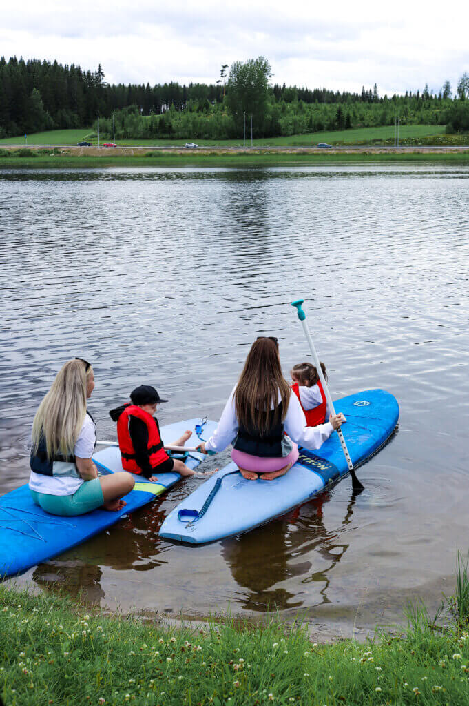 Perhe SUP-lautojen päällä. Kaksi aikuista ja kaksi lasta HImoksen Patalahdella.