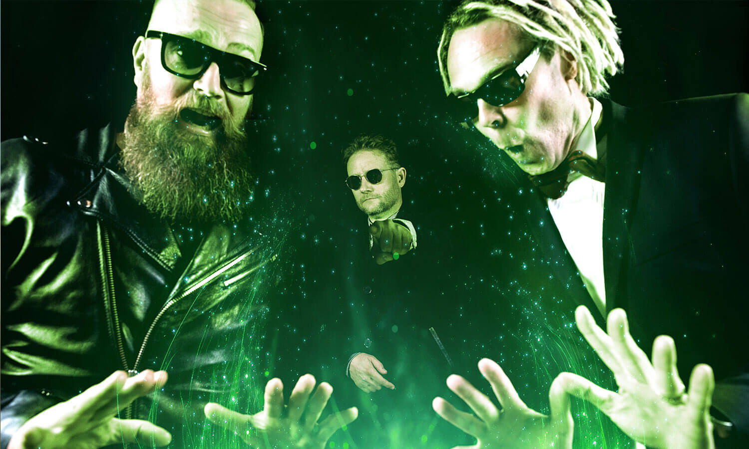 Raptori-yhtye, 3 henkilöä, kuvassa, jossa alareunassa on vihreää, muuten kuva on tumma. Artisteilla on aurinkolasit ja he työntävät käsiään kohti kameraa kuvan alaosassa.