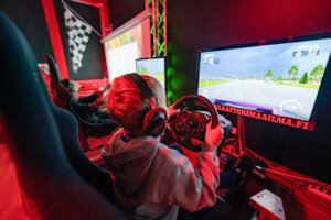 Lapsia pelaamassa Willin Lännen Simulaattorimaailmassa racing-simulaattoreilla.
