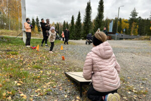 Joukko lapsia ja aikuisia Himoksella ulkona syyskelissä. Lapsi heittää hernepussia koloon, jonka edessä toinen laskee pisteitä.
