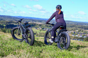 Fatbike-pyöräilijä katsoo kauas kesäistä maisemaa Himosvuoren päällä.