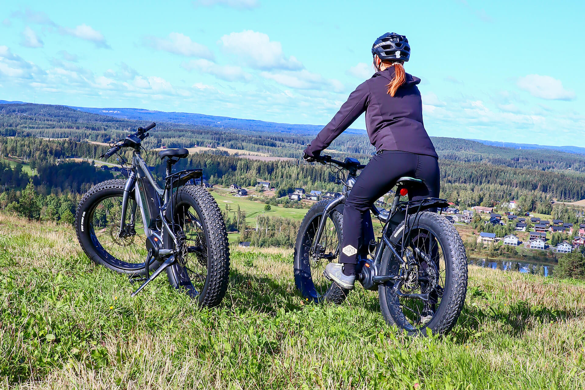 Fatbike-pyöräilijä katsoo kauas kesäistä maisemaa Himosvuoren päällä.