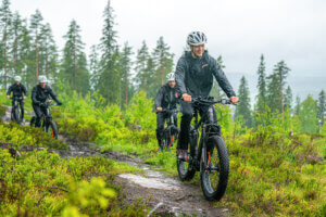 Porukka ajaa sähkökäyttöisillä fatbikeilla luonnossa Himosvuoren päällä.