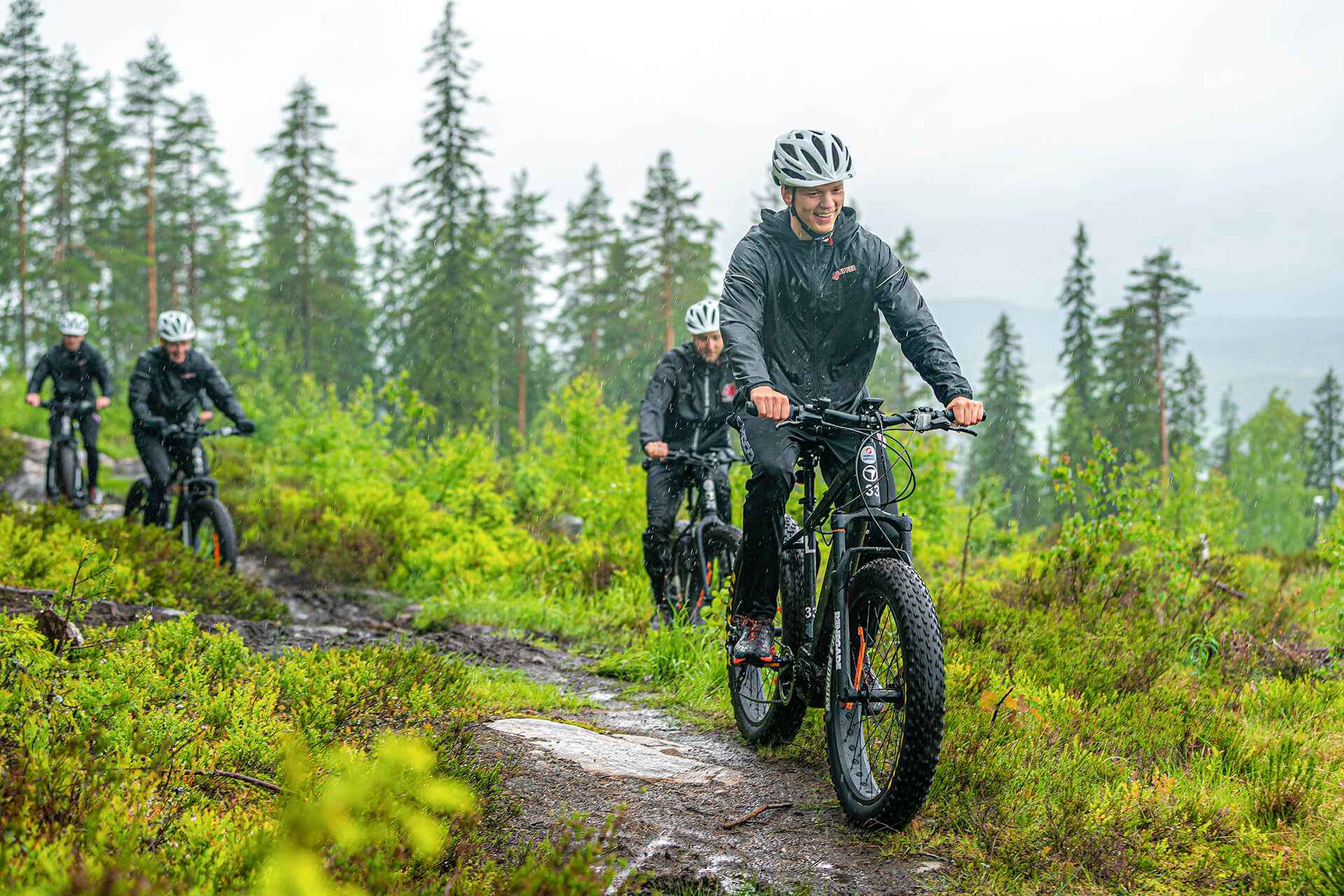 Porukka ajaa sähkökäyttöisillä fatbikeilla luonnossa Himosvuoren päällä.