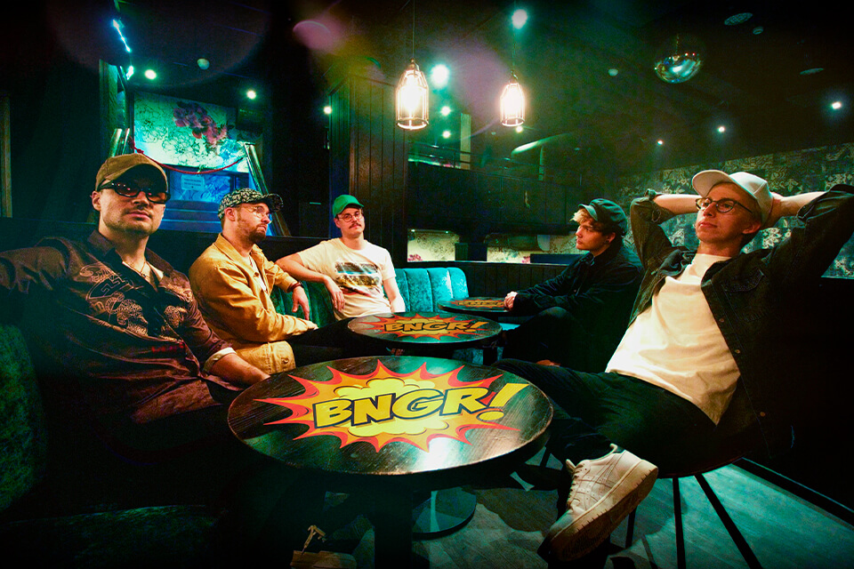 Viisi BNGR!:n jäsentä istuu pöydän äärellä baariympäristössä.