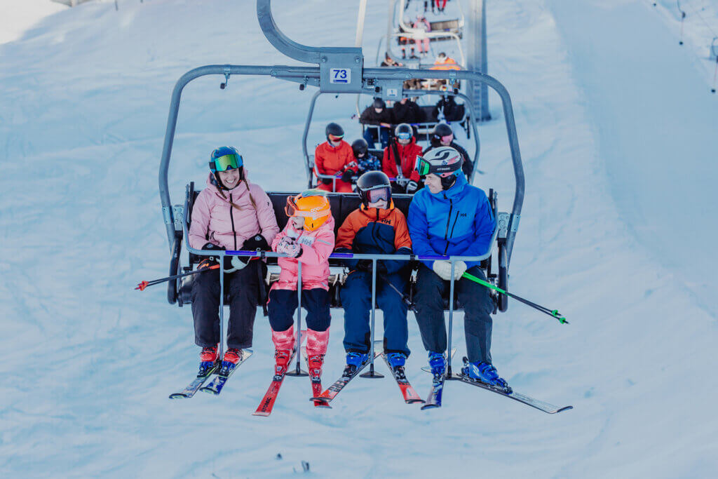 Perhe tuolihississänousemassa rinnettä ylös. Kuva: Himos hiihtokeskus.