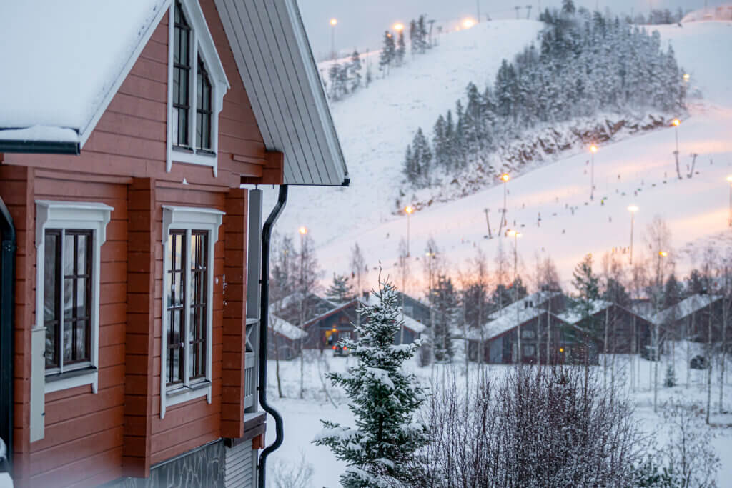 Mökkejä ja taustalla valaistut Himoksen rinteet.