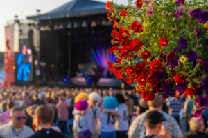 Iskelmä Festivaali Himoksella vuonna 2025. Edessä punaisia kukkia ja taustalla iso yleisömeri.