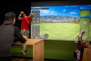 Mies pelaa golfsimulaattorilla Himoksen Willissä Lännessä.