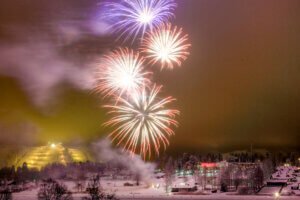 Ilotulitusraketteja Himoksella vuodenvaihtuessa, taustalla Himos Parkin kenttä sekä laskettelurinteet.