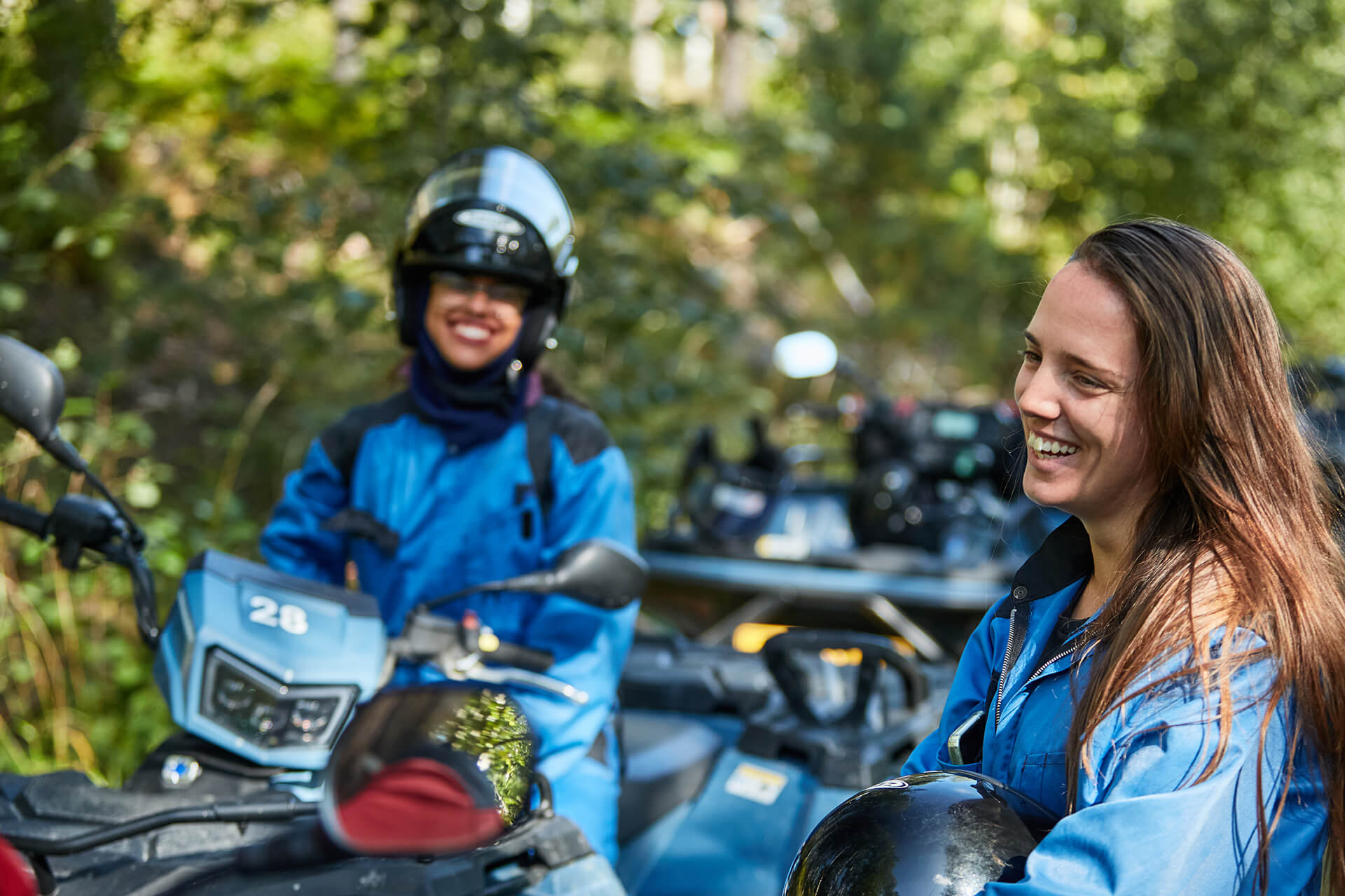 Mönkijöillä ajelevat ihmiset pitävät taukoa metsän keskellä.