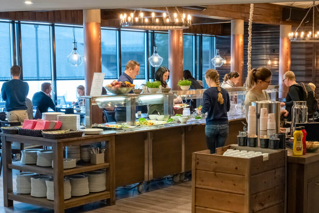 Ihmisiä ruokailemassa ja hakemassa ruokaa buffet-pöydästä Himoksen Tupa kitchen&bar -ravintolassa.